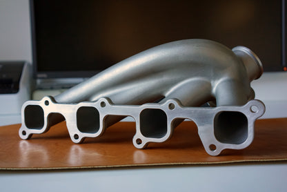 Cast 347 stainless Volvo 8-valve turbo manifold showing cylinder head flange and precision-machined mating surface